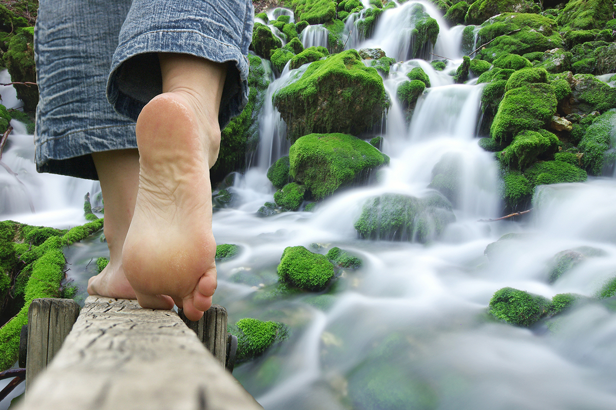 Person walking along a wooded log